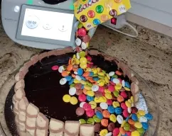 Step <p>-Pinta un palillo chino o pajita con la cobertura de chocolate y pega los Lacasitos. Esparce el resto de Lacasitos por el pastel y cubre el lateral con barritas de chocolate.</p><p>-Introduce una servilleta en la bolsa de Lacasitos antes de colocarla sobre el palillo.</p> illustration