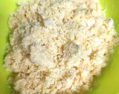 Step <p>Vertemos la masa en un bol grande, añadimos el resto del coco rallado y acabamos de mezclar a mano.</p><p>Tiene que quedar una mezcla bastante seca no os asustéis.</p> illustration