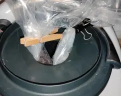 Step <p>Coloca el chocolate troceado dentro de una bolsa para congelar o de una manga pastelera. Cierra los extremos abiertos con la ayuda de pinzas de plástico para envases.</p> illustration