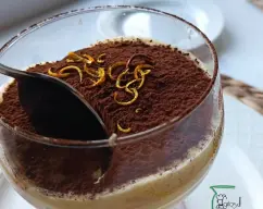 Step <p>Remoje los bizcochos restantes y colóquelos sobre la crema y cubra con el resto de de la mezcla de mascarpone. Cubra con film transparente y refrigere 5 horas.</p><p>Espolvoree con naranja piel de naranja rallada o cortada y cacao en polvo. Corte y sirva</p> illustration